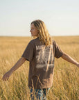 Woman wearing Matthew 5:3 Beatitudes tee in field back view - CarryTheCross