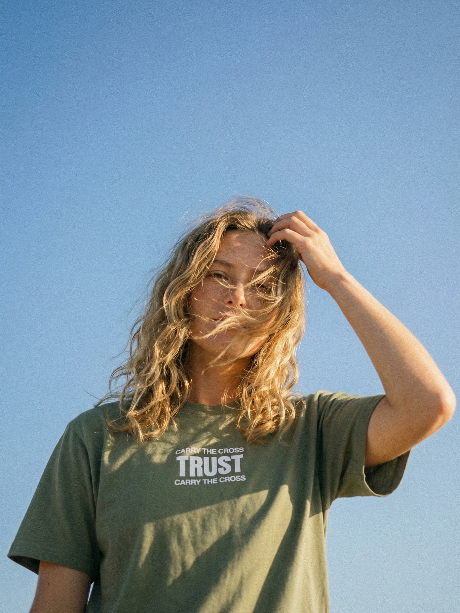 CTC approved original | pixels:c053d43a3cabaca26491b8adb8b69ca442958c459b615eeccb2f5b25fad993b6 | Trust Tee | source:blonde_trust-tee_sky-closeup.jpeg | side:front