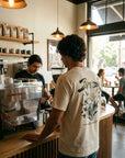 Man wearing Break Bread tee at coffee shop back view - CarryTheCross