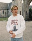 Man wearing the white Upon This Rock Christian crewneck outdoors, featuring the Matthew 16:18 front design | CarryTheCross