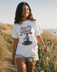 Woman wearing the white Upon This Rock Christian tee outdoors, featuring the Matthew 16:18 front design | CarryTheCross